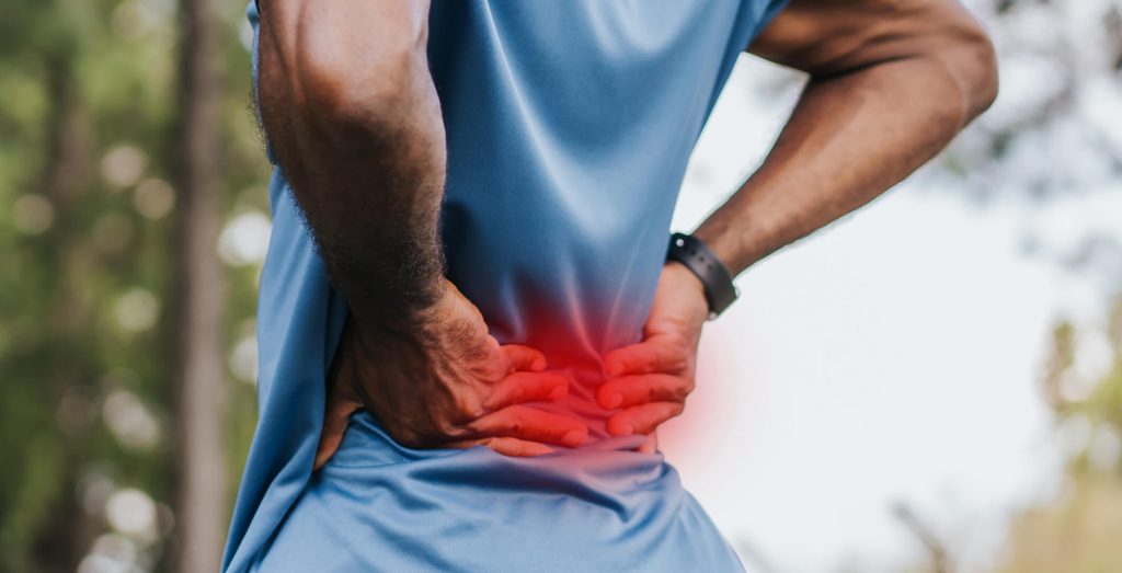 Image of someone gripping their lower back in pain.